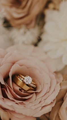 two wedding rings sitting on top of flowers