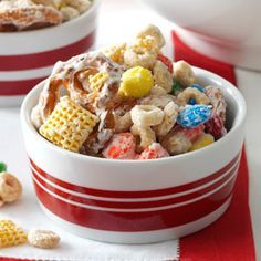 two bowls filled with cereal on top of a red and white striped table cloth next to candy