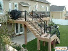 a house with a deck and stairs in the front yard