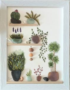 a white frame with some plants and rocks on it