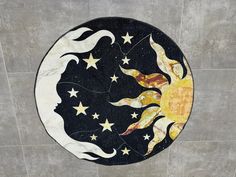 a black and white circular rug with stars and the moon on it's side