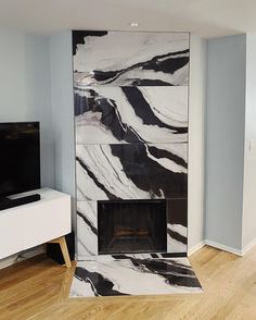 a living room with a fireplace and tv on the wall next to a white cabinet