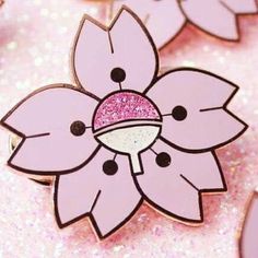 a pink flower brooch with glitter on it