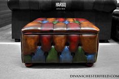 a colorful leather ottoman sitting on top of a floor