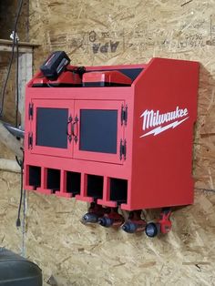 a red tool box mounted to the side of a wall