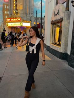 a woman is walking down the street talking on her cell phone while wearing black and white