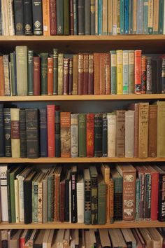 a book shelf filled with lots of books on top of wooden shelves next to each other