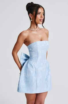 THE dress of the season has landed and you're going to be obsessed. Meet Elenora, our dreamy mini with a pretty tulip shaped skirt and waist cinching bodice. This strapless style is complete with lace up and a detachable, oversized bow to the back for perfect feminine drama. 



Colour: Blue.

Premium non-stretch floral jacquard.

Fully lined.

Strapless design.

Waist cinching.

Detachable, oversized bow detail to back.

Voluminous tulip shaped skirt.

Lace up to the reverse.

Invisible zipper. Homecoming Dresses Corset, Bow Mini Dress, Eve Dresses, Maxi Dress Sale, Off Shoulder Fashion, Sparkle Dress, Floral Jacquard, Dresses By Length, Formal Dresses Prom