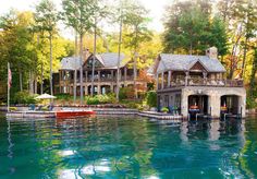 a house sitting on top of a lake surrounded by trees