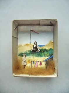 there is a small box with a painting on the inside that has clothes hanging out to dry