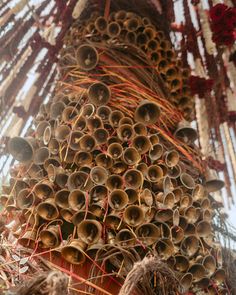 many bells are stacked on top of each other in the shape of a tree trunk