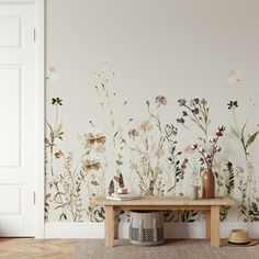 a room with flowers painted on the wall and a wooden bench in front of it