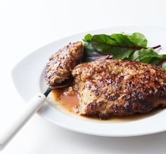 a white plate topped with meat and greens