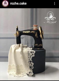 a black sewing machine with white lace on it's bottom and the words singer written in gold