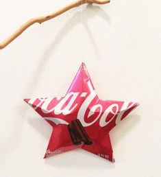 an ornament shaped like a star hanging from a branch with chocolate in it