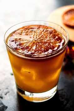 a glass filled with liquid sitting on top of a table