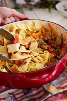 a red pot filled with pasta and meat