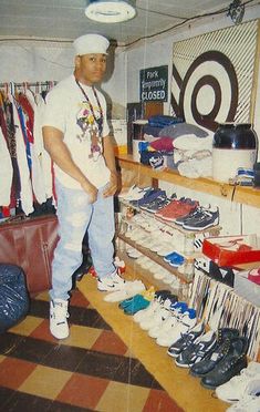 a man standing in front of a display of shoes and other items at a store