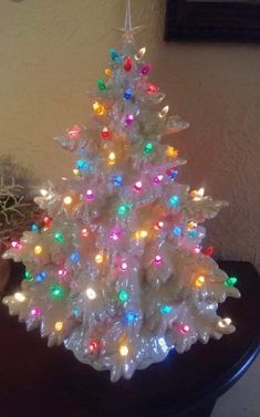 a small white christmas tree with multicolored lights