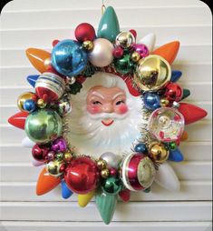 a christmas ornament hanging from the side of a wall with ornaments around it