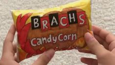 someone holding up a candy bar that reads brach's candy corn