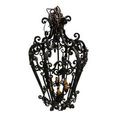 an ornate iron hanging light fixture with candles in it's caged design, isolated against a white background