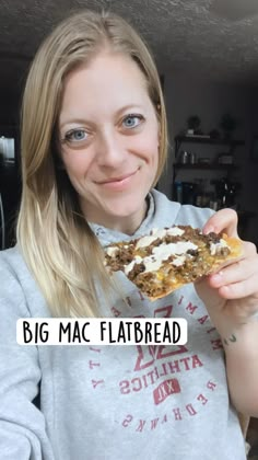 a woman holding up a piece of food in front of her face with the words big mac flatbread on it