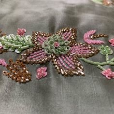 a close up view of an embroidered fabric with flowers on it