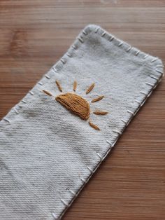 a piece of cloth with an embroidered sun on it sitting on top of a wooden table