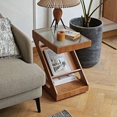 a living room with a couch, table and lamp on it's side stand