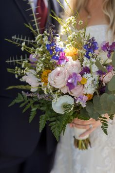 a bride and groom holding a bouquet of flowers