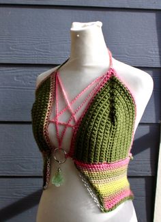 a white mannequin wearing a green and pink crochet halter top