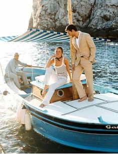 two men and a woman on a boat in the water