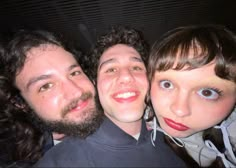 three people are posing for the camera with one another