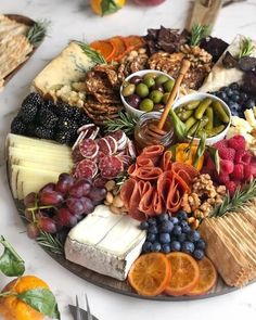 a platter filled with different types of cheeses and fruits