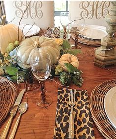 the table is set for thanksgiving dinner with pumpkins and gourds