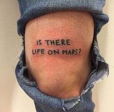 a person with a tattoo that says is there life on mars?