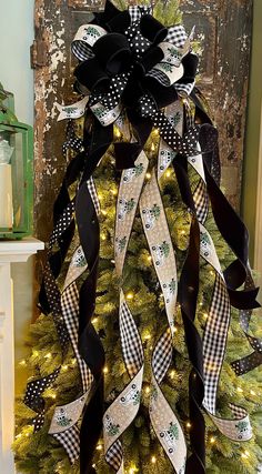 a christmas tree decorated with black and white ribbons