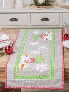 a christmas table runner with snowmen on it