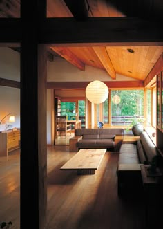 a living room filled with lots of furniture next to a wooden floor covered in windows