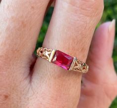 Gorgeous vintage gold plated ring featuring a red crystal stone and ornate detailing on the band. Band is marked '18K GP'. Size 7.75 Red Rectangular 14k Gold Ring, Red Ruby Birthstone Ring Stamped 14k, Victorian Ruby Ring In 14k Gold, Victorian 14k Gold Ruby Ring In Red, Red Ruby Ring Stamped 14k As Gift, Gold Ruby Crystal Ring With Birthstone, Gift Ruby Ring Red Stamped 14k, Gift Red Ruby Ring Stamped 14k, Red Birthstone Promise Ring Stamped 14k