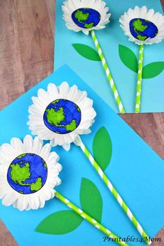 paper flowers made to look like the earth and two straws with green leaves on them