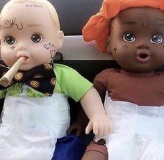 two dolls are sitting next to each other