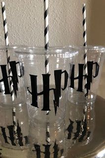 four plastic cups with black and white striped straws in the shape of h on them