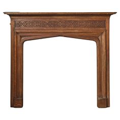 an antique wooden fireplace mantel with carvings on the top and sides, isolated against a white background