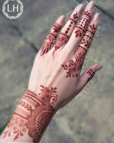 a woman's hand with henna tattoos on it