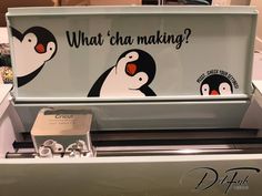 a sign with penguins on it that says what's making? and is in front of a display case