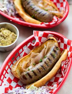 two hot dogs in buns on red and white plates