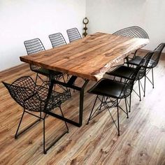 a dining room table with six chairs and a wood top on the floor in front of a window