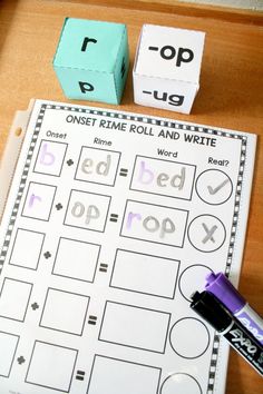 the word roll and write is on top of a wooden table with two cubes next to it